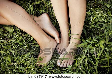 Stock Photo - Close up of feet of Caucasian women in grass. Fotosearch