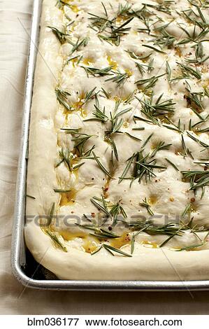 Stock Photo - Close up of focaccia dough with herbs. Fotosearch