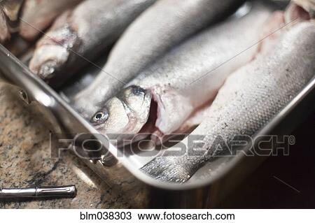 Stock Image - Close up of fresh fish in baking dish. Fotosearch