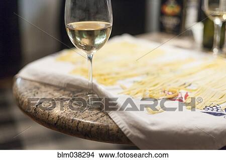 Picture - Close up of fresh pasta and glass of white wine. Fotosearch