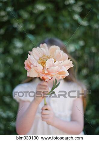 Stock Image - Close up of girl holding bouquet of flowers. Fotosearch
