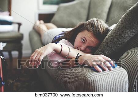 Close up of girl laying on sofa in living room View Large Photo Image Stock Image - Close up of girl laying on sofa in living room. Fotosearch