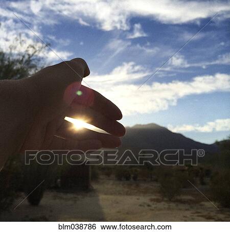 Close up of hand obscuring sunlight in field View Large Photo Image Stock Photograph - Close up of hand obscuring sunlight in field. Fotosearch