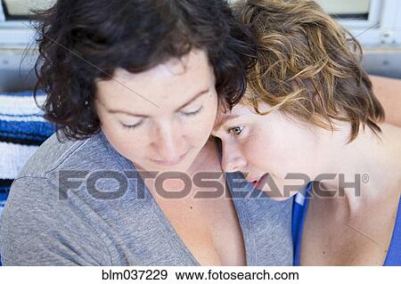 Stock Photo - Close up of lesbian couple hugging. Fotosearch