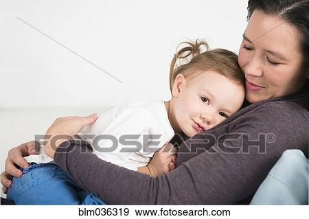 Close up of mother and daughter cuddling View Large Photo Image Stock Photo - Close up of mother and daughter cuddling. Fotosearch