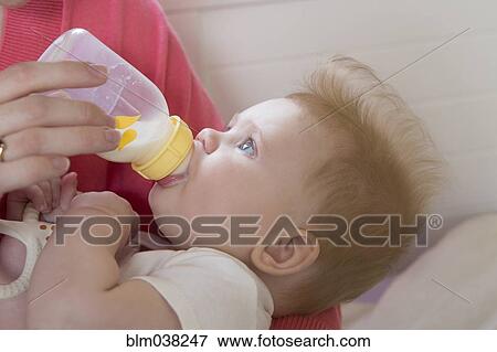 Close up of mother feeding baby girl View Large Photo Image Stock Photo - Close up of mother feeding baby girl. Fotosearch