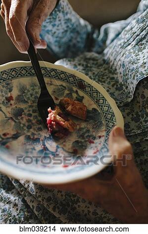 Picture - Close up of older mixed race woman eating. Fotosearch