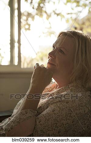 Stock Photo - Close up of older woman resting chin in hand. Fotosearch