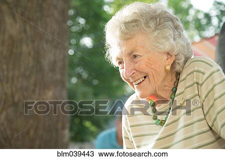 Stock Image - Close up of older woman smiling outdoors. Fotosearch