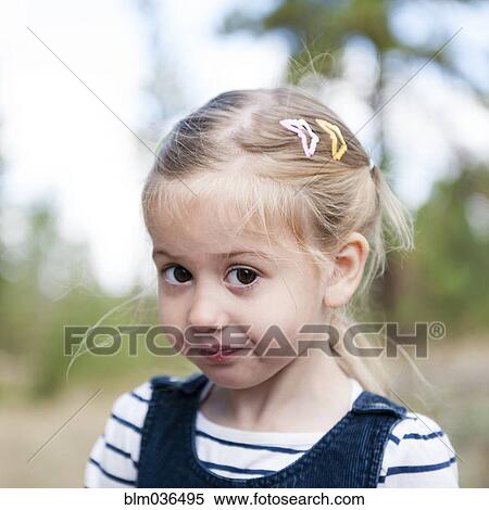 Stock Photography - Close up of serious Caucasian girl on hillside. Fotosearch