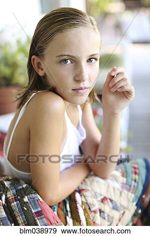 Stock Photo - Close up of serious girl sitting on porch. Fotosearch