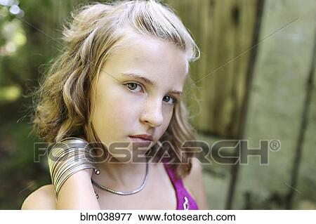 Close up of serious girl standing outdoors View Large Photo Image Stock Photo - Close up of serious girl standing outdoors. Fotosearch