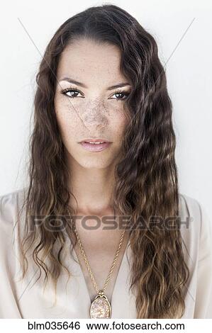 Stock Photograph - Close up of serious mixed race woman with curly hair. Fotosearch