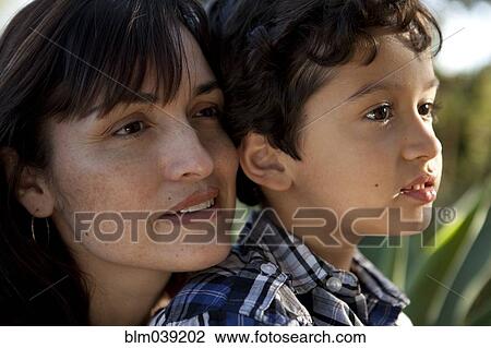 Stock Image - Close up of serious mother and son. Fotosearch