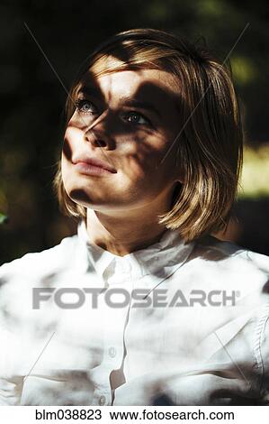 Stock Image - Close up of shadows on face of serious woman. Fotosearch