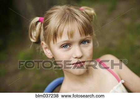 Stock Photo - Close up of smiling girl siting in backyard. Fotosearch