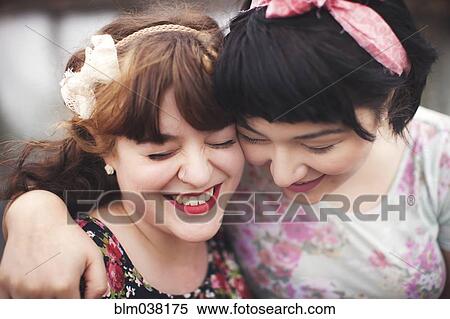Stock Photography - Close up of smiling women hugging. Fotosearch