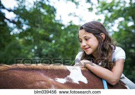 Stock Photograph - Close up of teenage girl riding horse. Fotosearch