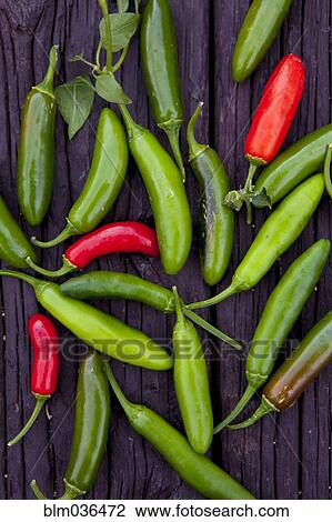 Stock Image - Close up of variety of chili peppers on board. Fotosearch