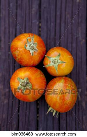 Stock Photo - Close up of variety of fresh tomatoes on board. Fotosearch
