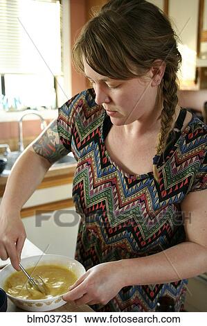 Stock Image - Close up of woman cooking in kitchen. Fotosearch