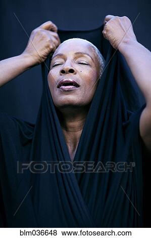 Close up of woman covering her head with shawl View Large Photo Image Stock Photo - Close up of woman covering her head with shawl. Fotosearch