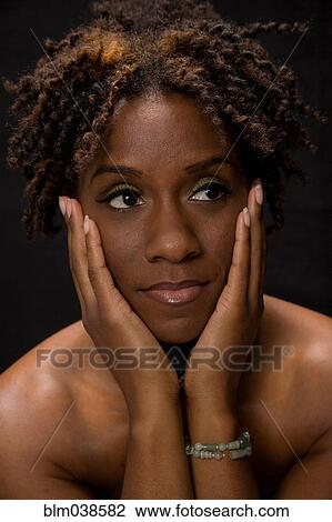 Stock Image - Close up of woman holding face in hands. Fotosearch