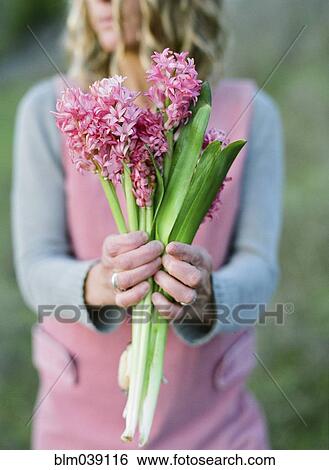 Stock Photograph - Close up of woman holding flower. Fotosearch