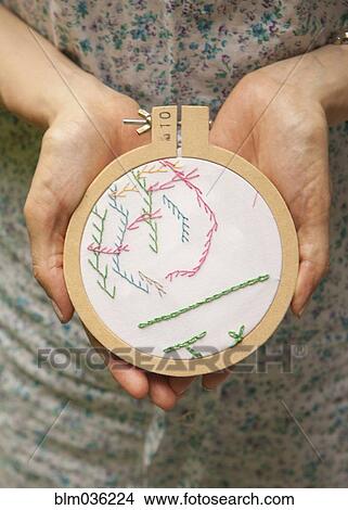 Picture - Close up of woman holding hand-stitched embroidery. Fotosearch