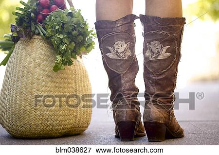 Close up of woman in boots with bag of produce View Large Photo Image Stock Photo - Close up of woman in boots with bag of produce. Fotosearch