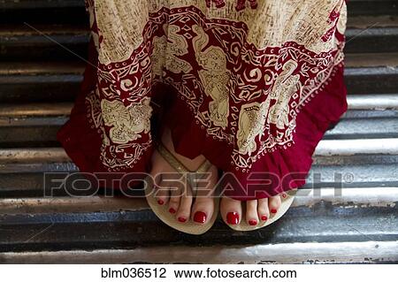Close up of woman in traditional skirt and flip flops View Large Photo Image Stock Image - Close up of woman in traditional skirt and flip flops. Fotosearch