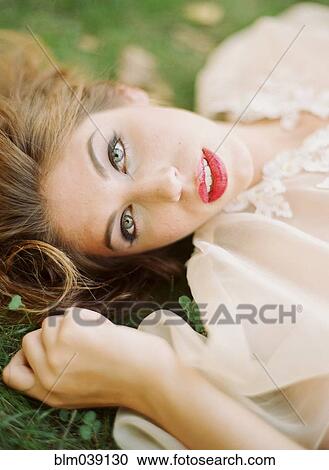 Close up of woman laying in grass View Large Photo Image Stock Image - Close up of woman laying in grass. Fotosearch