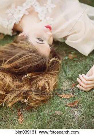 Close up of woman laying in grass View Large Photo Image Stock Image - Close up of woman laying in grass. Fotosearch