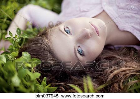 Stock Photography - Close up of woman laying in grass. Fotosearch