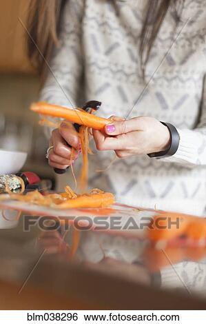 Stock Photograph - Close up of woman peeling carrot. Fotosearch