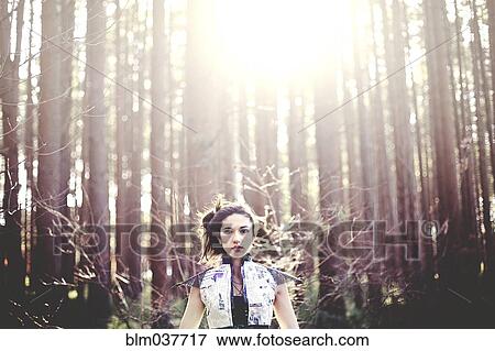 Stock Photo - Close up of woman standing under trees. Fotosearch