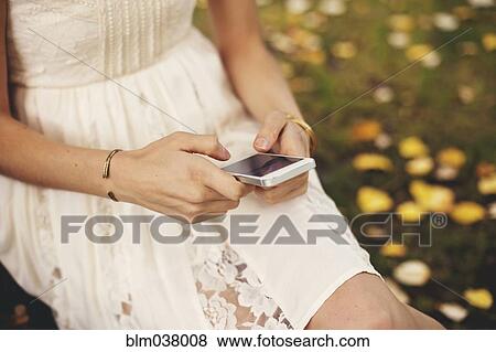 Stock Photo - Close up of woman using cell phone outdoors. Fotosearch