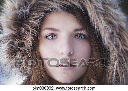 Stock Image - Close up of woman wearing fur hood. Fotosearch