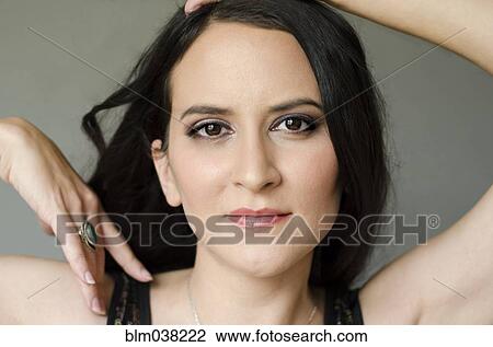 Stock Image - Close up of woman with arms raised. Fotosearch