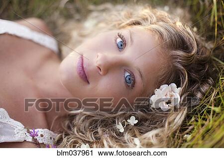 Close up of woman with blue eyes laying in grass View Large Photo Image Stock Image - Close up of woman with blue eyes laying in grass. Fotosearch