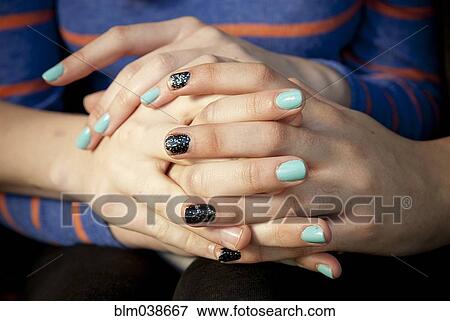 Stock Photo - Close up of women holding hands. Fotosearch