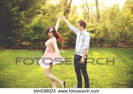 Stock Image - Couple dancing in grass. Fotosearch