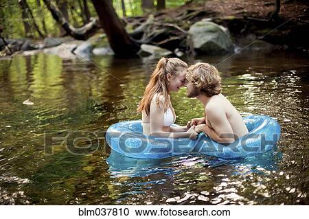 Stock Image - Couple holding hands in forest river. Fotosearch