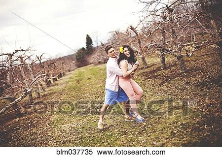 Couple hugging and taking photographs in vineyard View Large Photo Image Stock Photography - Couple hugging and taking photographs in vineyard. Fotosearch