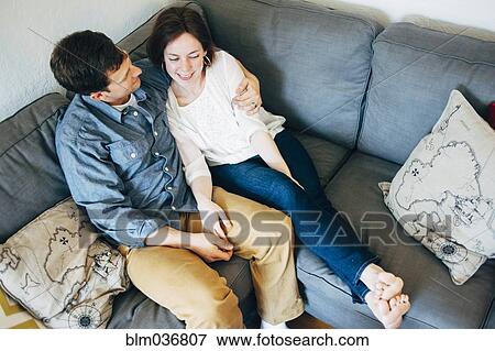 Stock Photo - Couple hugging on sofa. Fotosearch