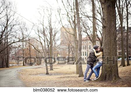 Couple kissing in urban park View Large Photo Image Stock Image - Couple kissing in urban park. Fotosearch