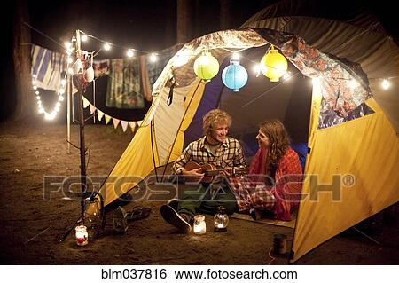 Couple playing music in camping tent at night View Large Photo Image Stock Photograph - Couple playing music in camping tent at night. Fotosearch