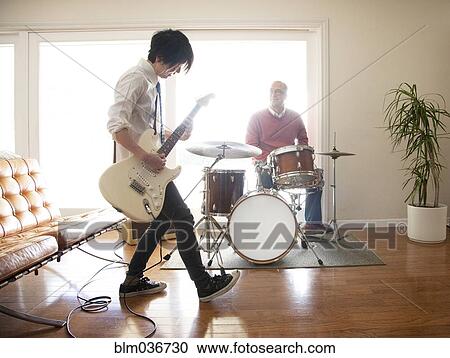 Stock Image - Couple playing music in living room. Fotosearch