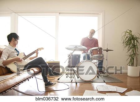 Stock Image - Couple playing music in living room. Fotosearch
