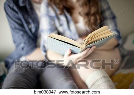 Stock Photo - Couple reading book together on bed. Fotosearch